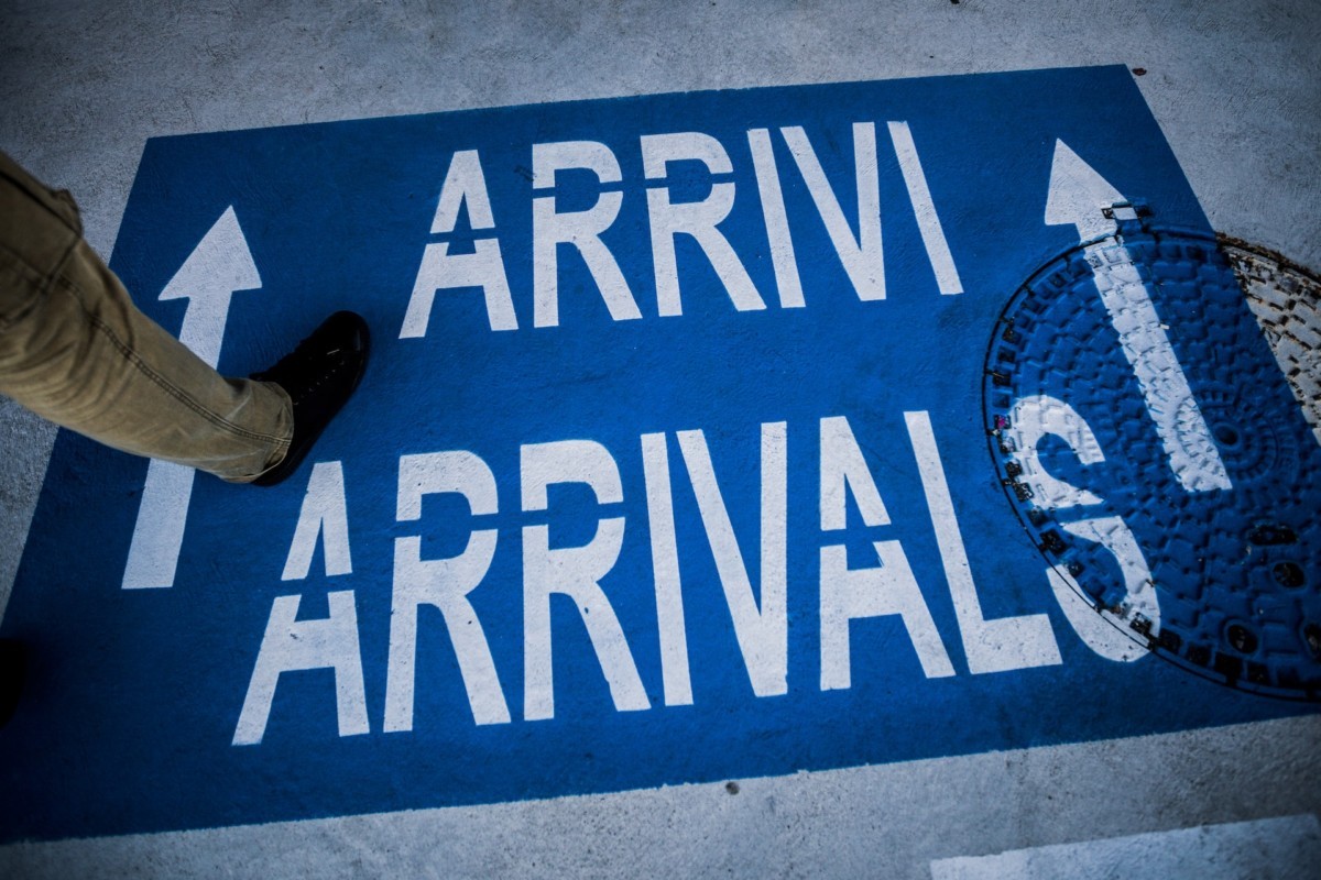 floor sign signaling the way to arrivals